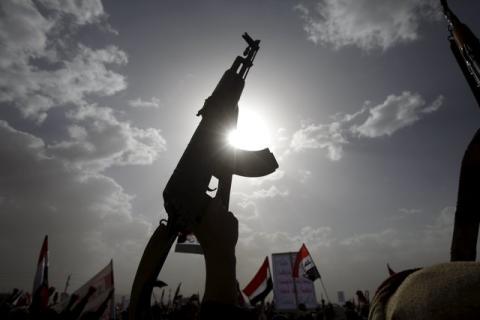 A Houthi follower rises a weapon as he attends a rally marking one year of Saudi-led air strikes, in Yemen's capital Sanaa, March 26, 2016. PHOTO BY REUTERS/Mohamed al-Sayaghi