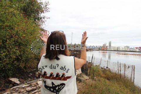 Duwamish Tribal Services Executive Director Jolene Haas holds up her hands, a traditional gesture of gratitude, on the banks of the Duwamish River in Seattle, USA. PHOTO BY Thomson Reuters Foundation/Gregory Scruggs