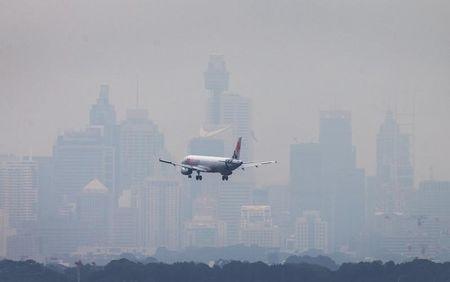 An Australian commercial aircraft prepares to land in the haze at Sydney's International Airport, July 15, 2014. PHOTO BY REUTERS/Jason Reed