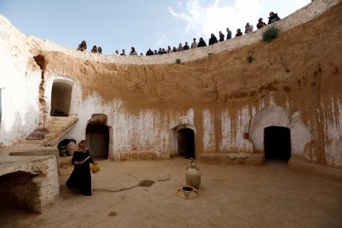 Tunisian tourists watch as Saliha Mohamedi, 36, walks around her troglodyte house on the outskirts of Matmata, Tunisia, February 4, 2018. "I don't want to leave my house, it would be as if I was throwing my life and my traditions away," Saliha said. PHOTO BY REUTERS/Zohra Bensemra