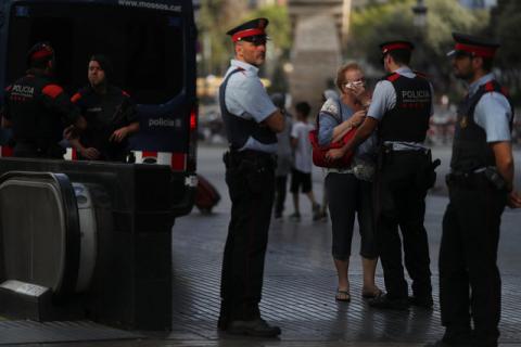 Pilar Revilla, 75, gets emotional after hugging a Catalan Mossos d'Esquadra officer after visiting an impromptu memorial where a van crashed into pedestrians at Las Ramblas in Barcelona, Spain, August 20, 2017. PHOTO BY REUTERS/Susana Vera