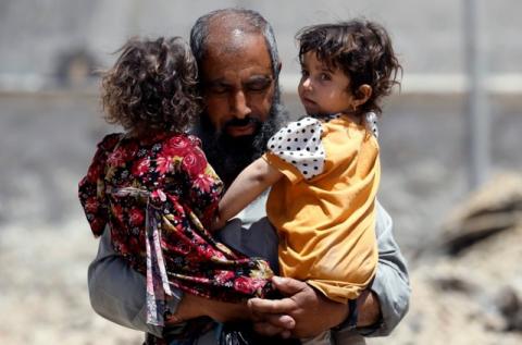 A girl looks out from the arms of a displaced resident, who fled home due to the ongoing fighting between the Iraqi forces and Islamic State militants near the Old City in western Mosul, Iraq, June 13, 2017. PHOTO BY REUTERS/Erik De Castro
