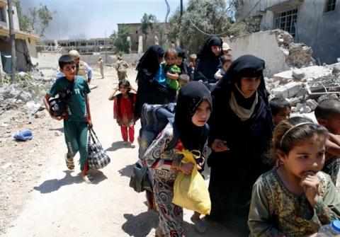 Displaced civilians walk towards the Iraqi Army positions after fleeing their homes due to clashes in the Shifa neighbourhood in western Mosul, Iraq, June 15 2017. PHOTO BY REUTERS/Erik De Castro
