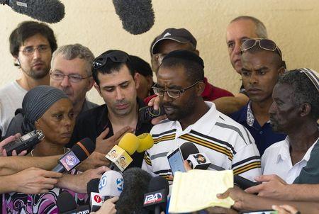 Ilan Mangisto (C), the brother of Avraham Mangisto, speaks to the media as their parents stand with him, outside their home in the southern city of Ashkelon, Israel, July 9, 2015. PHOTO BY REUTERS/Amir Cohen