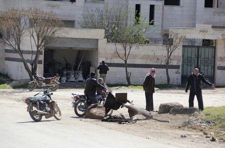 People inspect a site targeted by what activists said was a poison gas attack in the village of Sarmin in Idlib province, March 17, 2015. PHOTO BY REUTERS/Mohamad Bayoush