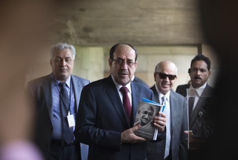 Iraqi Prime Minister Nuri al-Maliki (2nd L) holds a book of Mahatma Gandhi at his memorial at Rajghat in New Delhi