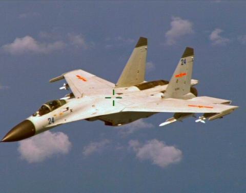 File photo of a Chinese J-11 fighter jet seen flying near a U.S. Navy P-8 Poseidon about 215 km (135 miles) east of China's Hainan Island, August 19, 2014. PHOTO BY REUTERS/U.S. Navy