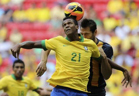 Brazil's Jo (front) heads a ball next to Australia's Sasa Ognenovski during their international friendly soccer match in Brasilia