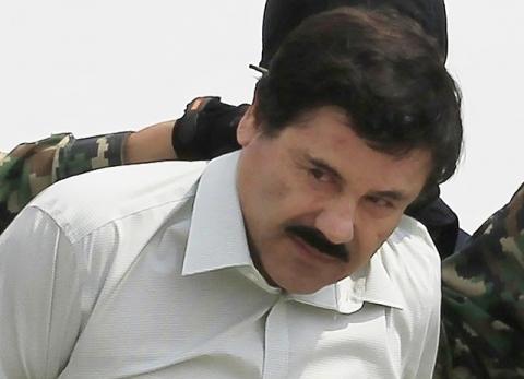 Joaquin "El Chapo" Guzman is escorted by soldiers during a presentation at the Navy's airstrip in Mexico City, February 22, 2014. REUTERS/Henry Romero
