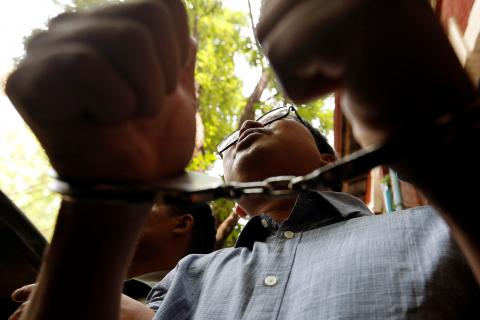 Detained Reuters journalist Wa Lone gives a thumbs up as he is escorted by police after a court hearing in Yangon, Myanmar April 4, 2018. PHOTO BY REUTERS/Ann Wang