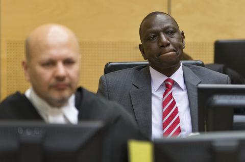 Kenya's Deputy President William Ruto (R) reacts as he sits in the courtroom before his trial at the International Criminal Court (ICC)