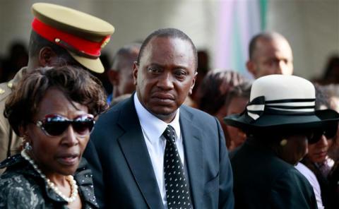 Kenyan President Uhuru Kenyatta (C) joins his relatives as he attends the burial of his nephew Mbugua Maina and Maina's fiancee Rosemary Wahito