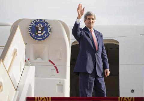 U.S. Secretary of State John Kerry waves as he departs Abu Dhabi International Airport