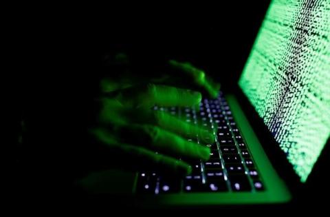 A man types on a computer keyboard in front of the displayed cyber code in this illustration picture taken on March 1, 2017. PHOTO BY REUTERS/Kacper Pempel/Illustration