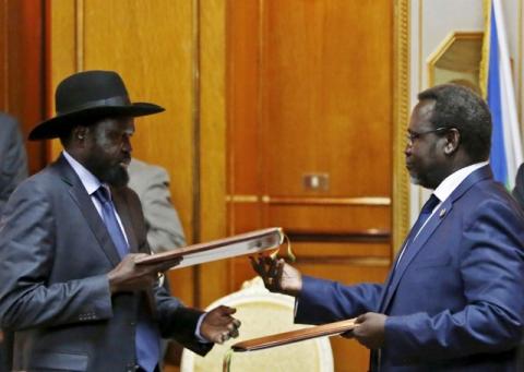 South Sudan's rebel leader Riek Machar (R) and South Sudan's President Salva Kiir exchange signed peace agreement documents in Addis Ababa, May 9, 2014. PHOTO BY REUTERS/Goran Tomasevic