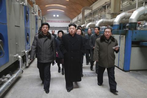North Korean leader Kim Jong Un (front C) gives field guidance at the Kim Jong Suk Pyongyang Textile Mill in this undated photo released by North Korea's Korean Central News Agency (KCNA) in Pyongyang, December 20, 2014. PHOTO BY REUTERS/KCNA