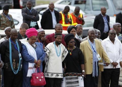 AbaThembu King Buyelekhaya Dalindyebo (3rd L) looks on with some members of his family as former South African President Nelson Mandela's flag-draped coffin arrives at the Mthatha airport, in the Eastern Cape province, 900 km (559 miles) south of Johannesburg for a funeral, December 14, 2013. PHOTO BY REUTERS/Siphiwe Sibeko