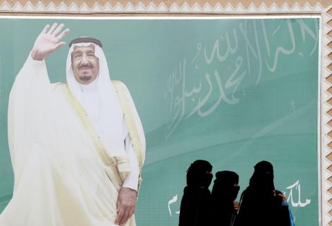 Women walk past a poster of Saudi Arabia's King Salman bin Abdulaziz Al Saud during Janadriyah Cultural Festival on the outskirts of Riyadh, Saudi Arabia, February 12, 2018. PHOTO BY REUTERS/Faisal Al Nasser