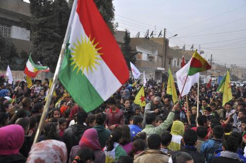 Kurdish civilians gather in the Syrian Kurdish city of Qamishli as they wave Kurdish flags in celebration after it was reported that Kurdish forces took control of the Syrian town of Kobani, January 27, 2015. PHOTO BY REUTERS/Delil Souleiman