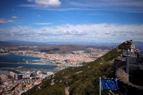 A general view shows the Spanish city of La Linea de la Concepcion (rear) and the tarmac of the Gibraltar International Airport (bottom L) while tourists stand on the top of the Rock (R) next to the European Union flag, in the British overseas territory of Gibraltar, September 14, 2016. PHOTO BY REUTERS/Jon Nazca