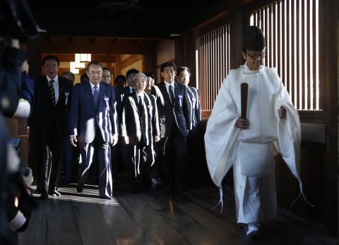 A group of lawmakers including Japan's ruling Liberal Democratic Party (LDP) lawmaker Hidehisa Otsuji (3rd L) are led by a Shinto priest as they visit Yasukuni Shrine in Tokyo