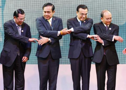 Cambodia's Prime Minister Hun Sen (L-R), Thailand's Prime Minister Prayuth Chan-ocha, China's Premier Li Keqiang and Myanmar's President Thein Sein join hands before posing for photographers during the opening ceremony of the 5th Greater Mekong Subregion (GMS) Summit at a hotel in Bangkok, December 20, 2014. PHOTO BY REUTERS/Chaiwat Subprasom