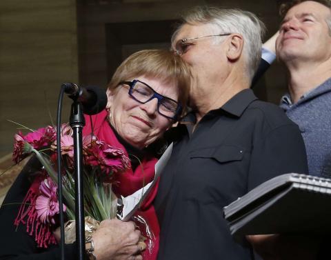 Lee Carter (L) embraces her husband Hollis Johnson while speaking to journalists at the Supreme Court of Canada in Ottawa February 6, 2015. Carter's mother, Kay Carter, traveled to Switzerland to end her life in 2010. PHOTO BY REUTERS/Chris Wattie