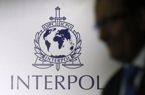 A man passes an Interpol logo during the handing over ceremony of the new premises for Interpol's Global Complex for Innovation, a research and development facility, in Singapore