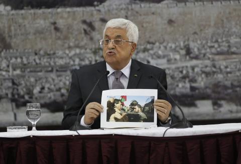 Palestinian President Mahmoud Abbas shows a picture of Palestinian minister Ziad Abu Ein as he is grabbed by an Israeli border policeman, during a meeting with the Palestinian leadership in the West Bank city of Ramallah, December 10, 2014. PHOTO BY REUTERS/Mohamad Torokman