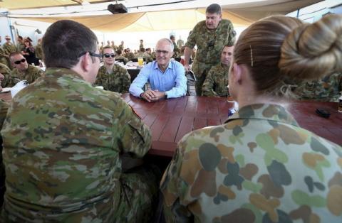 Australian Prime Minister Malcolm Turnbull (C) talks with Australian troops during breakfast at Camp Baird, located in the Middle East, during his visit to Iraq, January 16, 2016. PHOTO BY REUTERS/Alex Ellinghausen