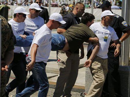 A man who disturbed security during a ceremony marking the 20th anniversary of the Srebrenica massacre, is carried away by security officers in Potocari, near Srebenica, Bosnia and Herzegovina, July 11, 2015. PHOTO BY REUTERS/Antonio Bronic