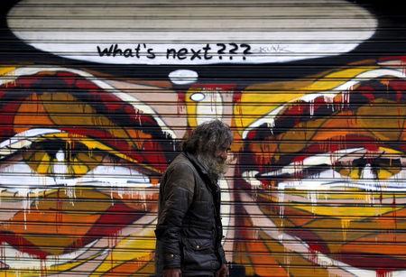 A man walks by a mural in Athens, Greece, July 14, 2015. PHOTO BY REUTERS/Yannis Behrakis