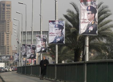 A man stands on a bridge where huge posters of Egypt's Army chief Field Marshal Abdel Fattah al-Sisi are hanged in central Cairo