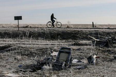 A man rides his bicycle past the wreckage of the Malaysia Airlines Flight MH17, near the village of Hrabove (Grabovo) in Donetsk region, in this December 15, 2014 file photo. PHOTO BY REUTERS/Maxim Shemetov