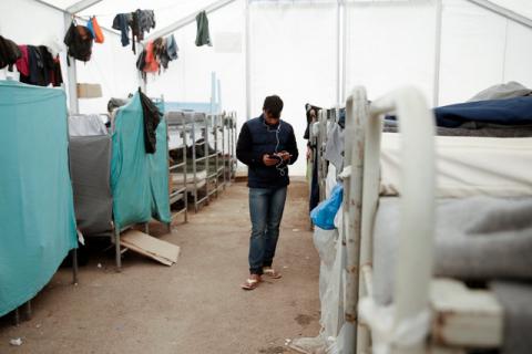 A young man from Afghanistan listens to music inside a tent at a camp for refugees and migrants in Schisto, near Athens, Greece, April 26, 2016. PHOTO BY REUTERS/Alkis Konstantinidis