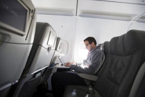 A man uses his laptop to test a new high speed inflight Internet service named Fli-Fi while on a special JetBlue media flight out of John F. Kennedy International Airport in New York, December 11, 2013. PHOTO BY REUTERS/Lucas Jackson