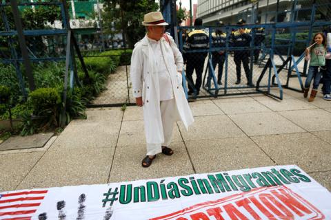 A man stands in front a banner reading "A day without migrants" during a protest outside the U.S Embassy in Mexico City, Mexico, September 5, 2017. PHOTO BY REUTERS/Alejandro Cegarra
