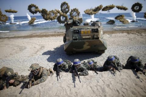 South Korean (blue headbands) and U.S. Marines take positions as amphibious assault vehicles of the South Korean Marine Corps fire smoke bombs during a U.S.-South Korea joint landing operation drill in Pohang, South Korea, March 12, 2016. PHOTO BY REUTERS/Kim Hong-Ji