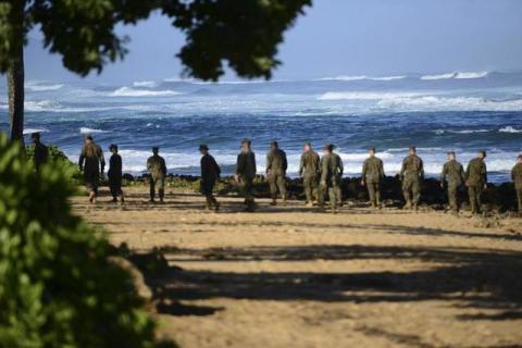 A group of Marines walk the beach outside the Haleiwa Incident Command Post in Haleiwa, Hawaii, during search efforts for 12 missing Marines, January 18, 2016. PHOTO BY REUTERS/U.S. Coast Guard