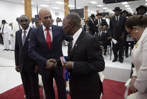 Haiti's outgoing President Michel Martelly (2L) shakes hands with the Senate President Jocelerme Privert (C) in presence of the Prime Minister Evans Paul during a ceremony marking the end of Martelly's presidential term, in the Haitian Parliament in Port-au-Prince, Haiti, February 7, 2016. PHOTO BY REUTERS/Andres Martinez Casares