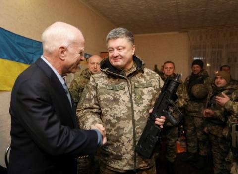 Ukrainian President Petro Poroshenko (R) shakes hands with U.S. Senator John McCain during a meeting with Ukrainian servicemen in Shirokino settlement near Mariupol, Ukraine, December 31, 2016. PHOTO BY REUTERS/Mikhail Palinchak