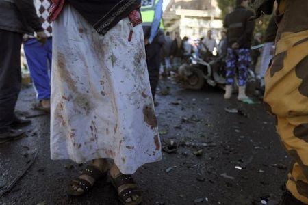 A medic with blood on his clothes stands at the scene of a car bomb attack outside the police college in Sanaa, January 7, 2015. PHOTO BY REUTERS/Mohamed al-Sayaghi