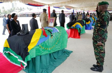 Members of Tanzania's Armed Forces salute their comrades bodies