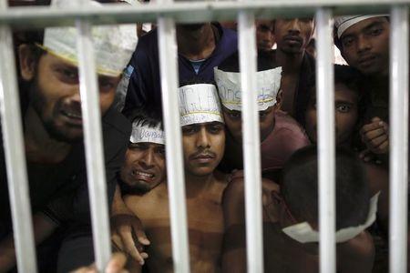 Men claiming to be from Bangladesh react from inside a communal cell at Songkhla Immigration Detention Centre (IDC), where they are kept with some Myanmar Rohingya people also rescued from human traffickers near Thailand's border with Malaysia, February 12, 2014. PHOTO BY REUTERS/Damir Sagolj