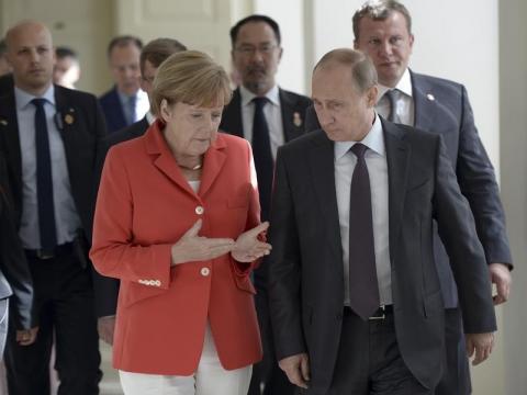 Russian President Vladimir Putin (R) and German Chancellor Angela Merkel walk during a meeting in Rio de Janeiro, July 13, 2014. PHOTO BY REUTERS/Alexey Nikolsky