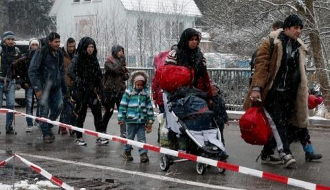 Migrants stay in queue during heavy snowfall before passing Austrian-German border in Wegscheid in Austria, near Passau, November 22, 2015. PHOTO BY REUTERS/Michael Dalder