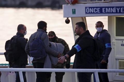 Frontex officers (R) guide migrants boarding a Turkish-flagged passenger boat to be returned to Turkey, on the Greek island of Lesbos, April 4, 2016. PHOTO BY REUTERS/Giorgos Moutafis