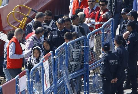 Migrants are escorted by Turkish police officers as they arrive in the Turkish coastal town of Dikili, Turkey, April 4, 2016. PHOTO BY REUTERS/Murad Sezer