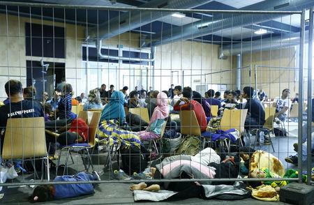 Asylum seekers from various countries wait to be registered inside a hall, used by German police as a makeshift reception centre for migrants, in Passau, Germany, July 29, 2015. PHOTO BY REUTERS/Michaela Rehle