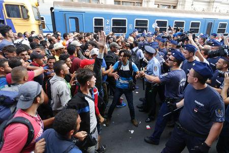 Migrants face Hungarian police in the main Eastern Railway station in Budapest, Hungary, September 1, 2015. PHOTO BY REUTERS/Laszlo Balogh